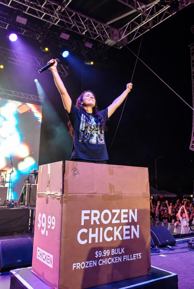 Musician on stage at Bonnaroo selling frozen chicken breast fillets for $9.99